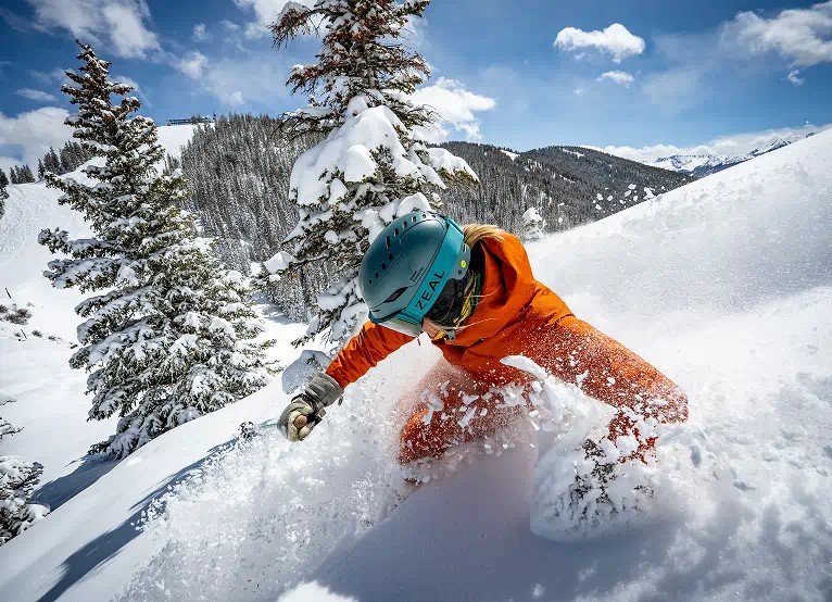 woman skies through deep powder on a blue bird day